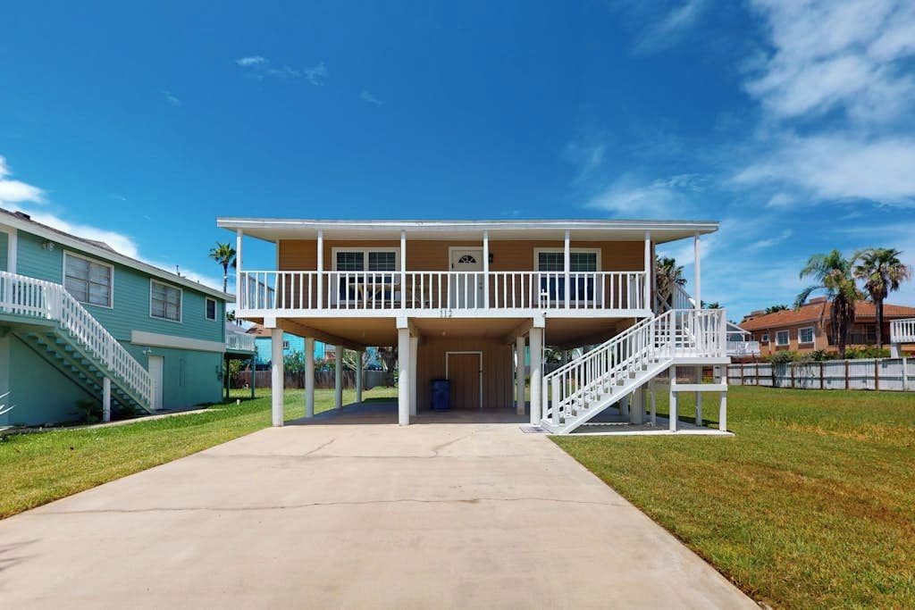 A two-story building with a covered front porch and a staircase leading to the upper level.