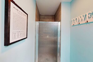 Ein Badezimmer mit einer Wortliste an der Wand, einer Dusche und einem Handtuchhalter.