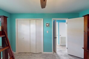 A hallway with a white door, a wooden ladder, and a door leading to another room. - Padre Island Paradise on Hibiscus (South Padre Island)