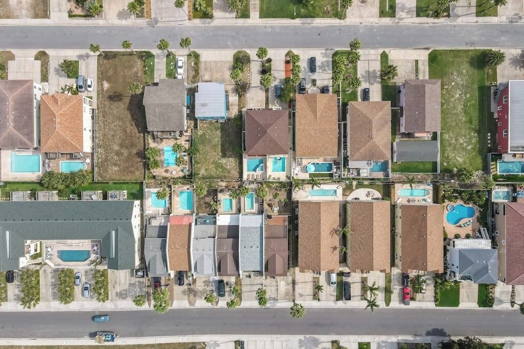 A residential area with multiple houses, each with a swimming pool.