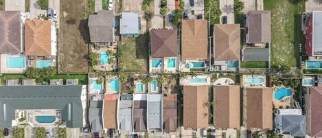 A residential area with multiple houses, each with a swimming pool.