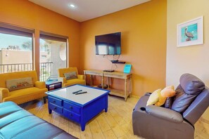 Ein Wohnzimmer mit einer Couch, einem Sessel und einem Couchtisch.