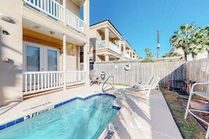 A residential pool area with a 3 ft no diving sign, outdoor seating, and a wooden fence. - Saturn Serenity 1 - Shared Pool & Dog-Friendly (South Padre Island)