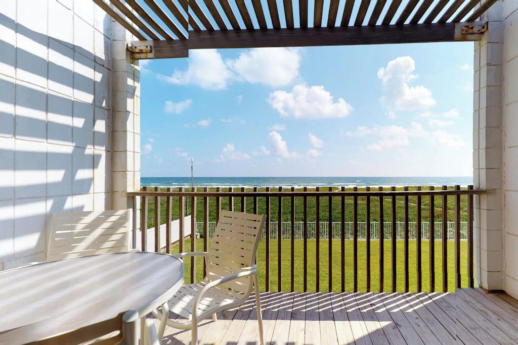 A covered outdoor seating area with a view of the sea.