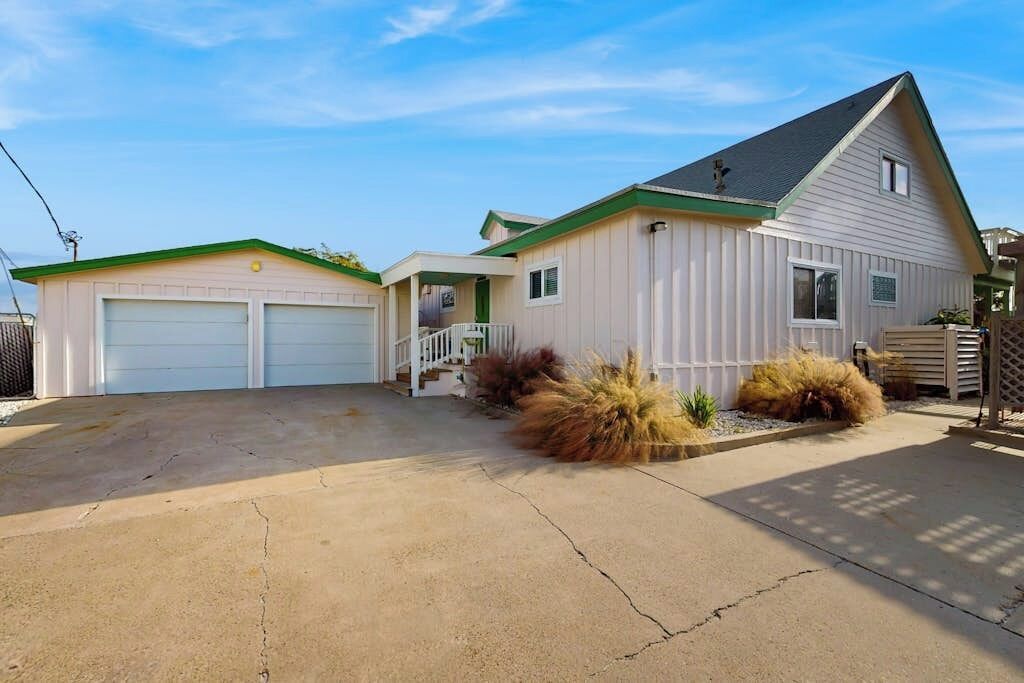 A two-story house with a garage, a covered porch, and a landscaped front yard.