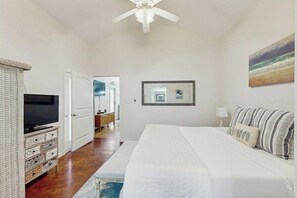 A bedroom with a bed, a television, a dresser, and a ceiling fan. - Anegada Village - Dreamcatcher (Corpus Christi)