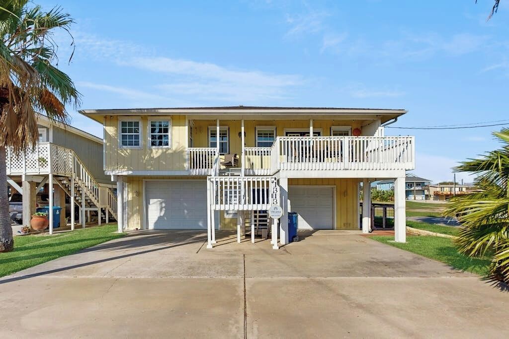 A two-story house with a front garage, a balcony on the upper floor, and a covered porch.