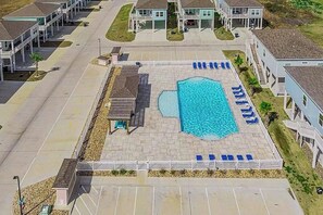 An aerial view of a residential area with a swimming pool surrounded by lounge chairs and a small pavilion. - Sunshine Paradise - Water Views, Pool & Big Patio (Rockport)