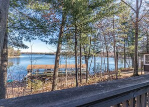 A lakeside property with a wooden deck, a dock, and a cabin. - Pinewood Cabin, Resort, Lake, Beach, Kayaks & More (Lac du Flambeau)