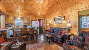 Un interior de cabaña acogedor con comedor, sala de estar y cocina.