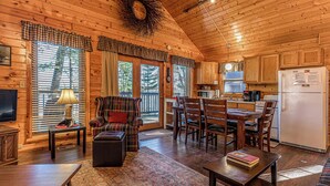 Interior acogedor de una cabaña con comedor, cocina y zona de estar.