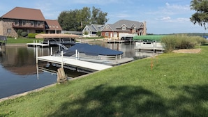Zona residencial con un canal, barcos amarrados y casas de fachada de piedra.