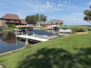 A residential area with a canal, docked boats, and houses with a stone facade.