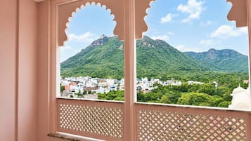 Una habitación con vista a un paisaje montañoso a través de una ventana con diseño de celosía.