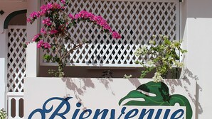 A white wall with a 'Bienvenue' sign and a green leaf design. - Island Heights (Orient Bay)