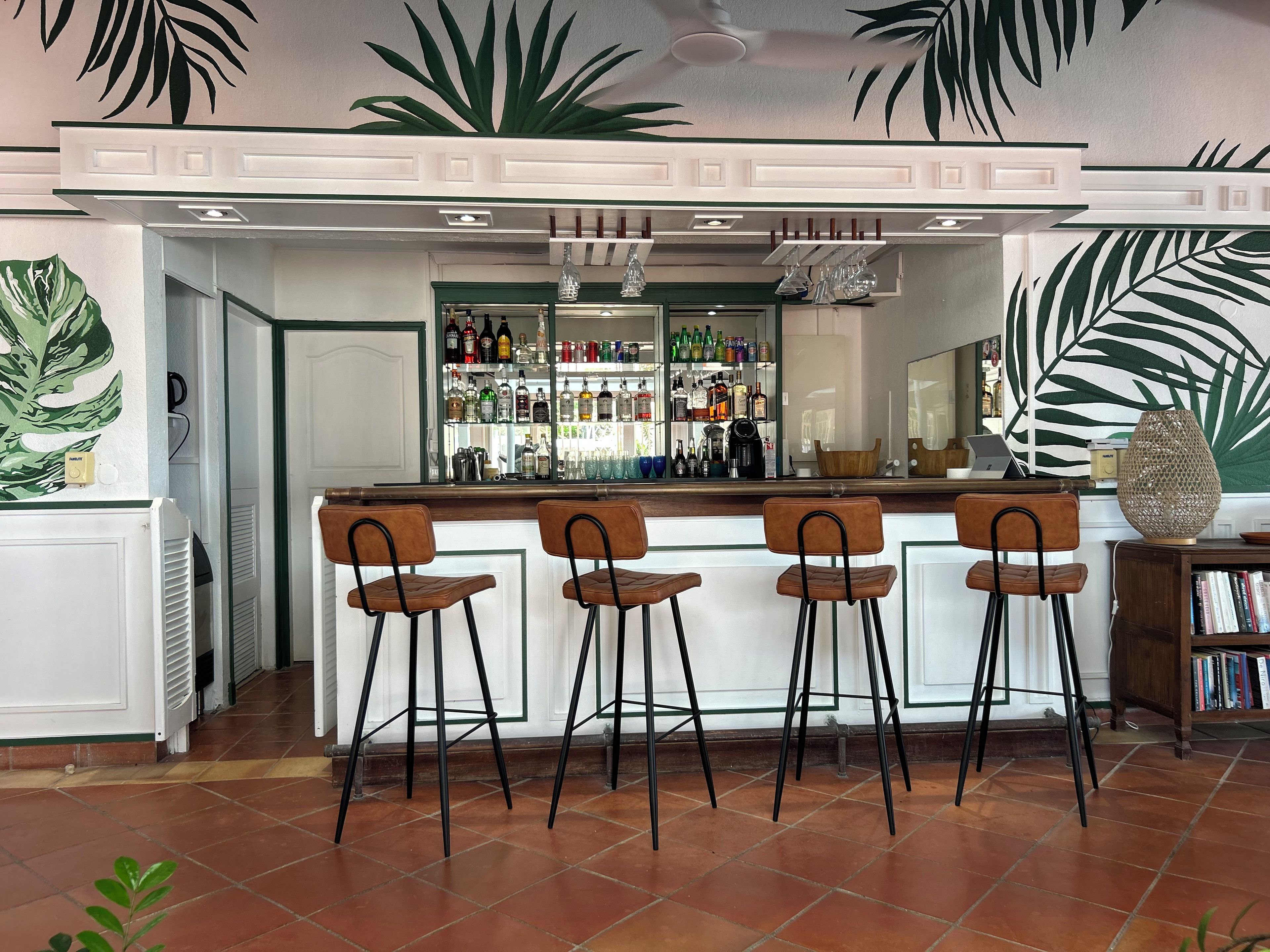 Un espace bar avec un comptoir, des tabourets et un assortiment de bouteilles.