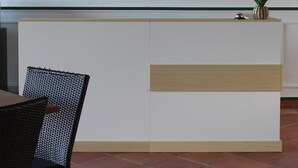 A reception desk with a sign that reads 'Island Heights Baie Orientale, St-Martin' and decorative green elements. - Island Heights (Orient Bay)