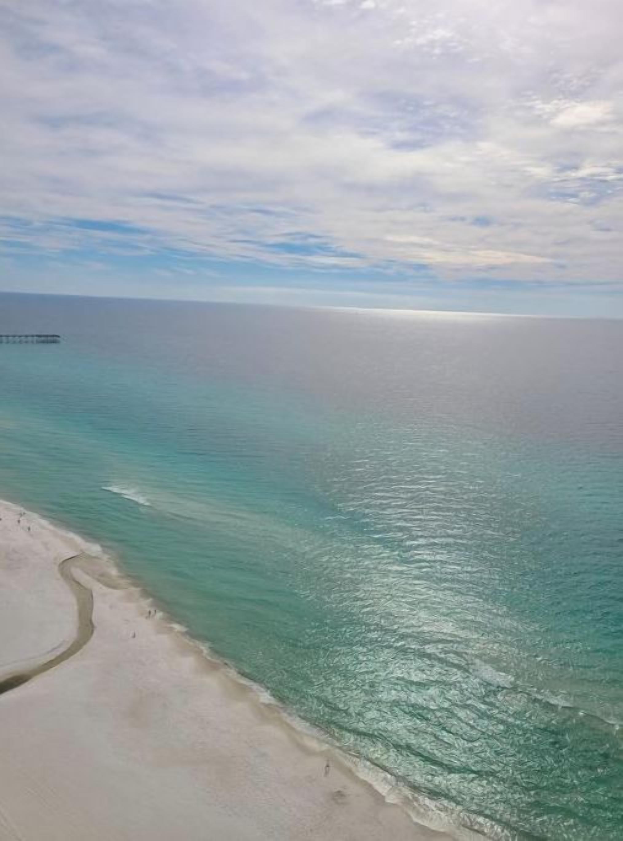 Een strand met helder turquoise water en een zandstrand.
