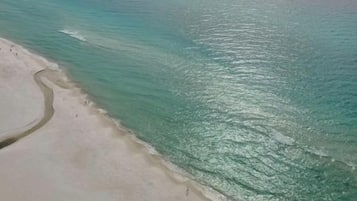 Een strand met helder turquoise water en een zandstrand.
