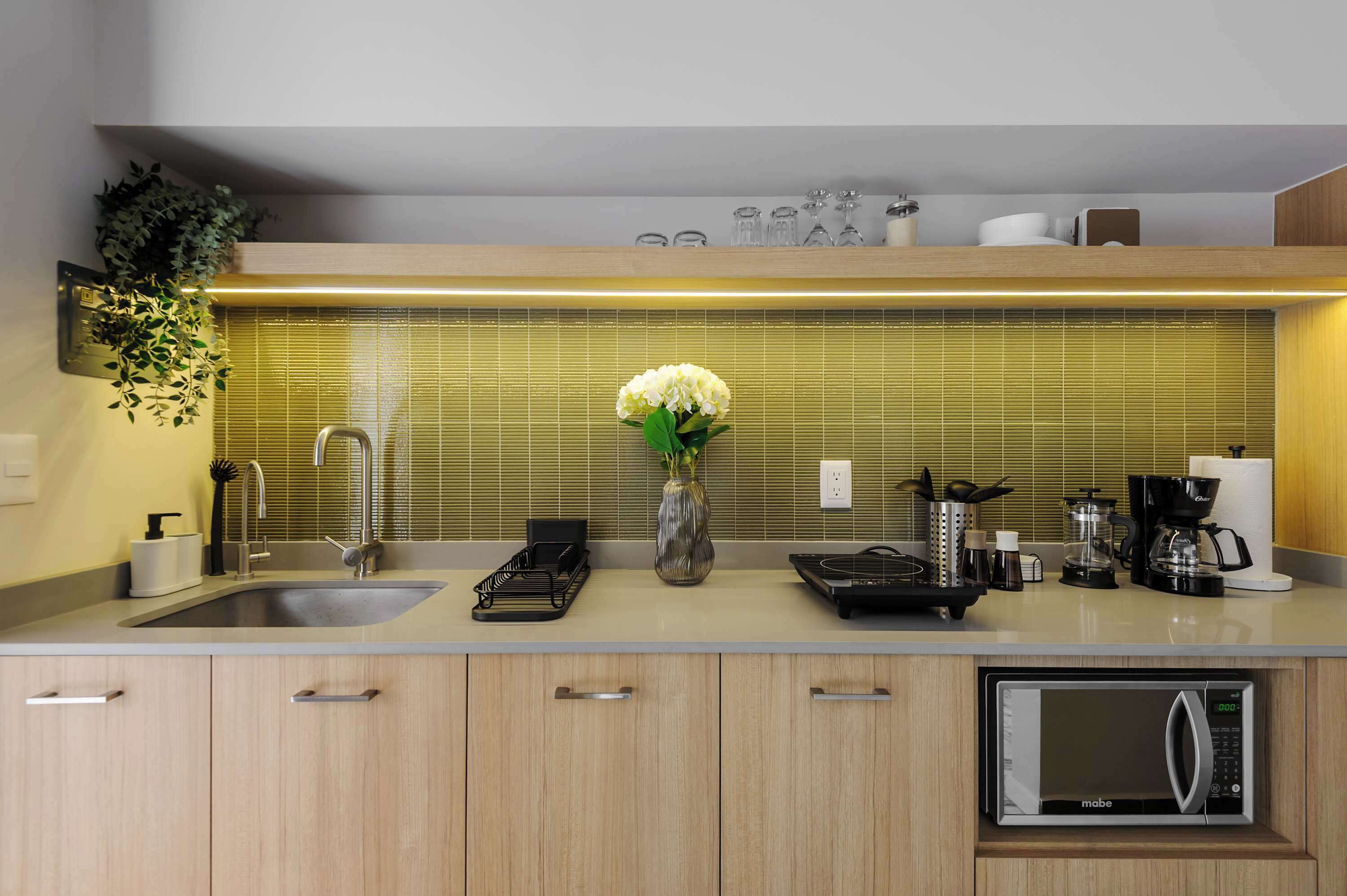 A modern kitchen with a built-in dishwasher, a coffee maker, and a microwave.