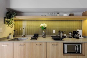 A modern kitchen with a built-in dishwasher, a coffee maker, and a microwave. - Zaterra - House with Independent Apartments in Roma Norte (Ciudad de México)