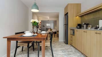 A modern kitchen with wooden cabinets, a built-in oven, and a coffee machine.