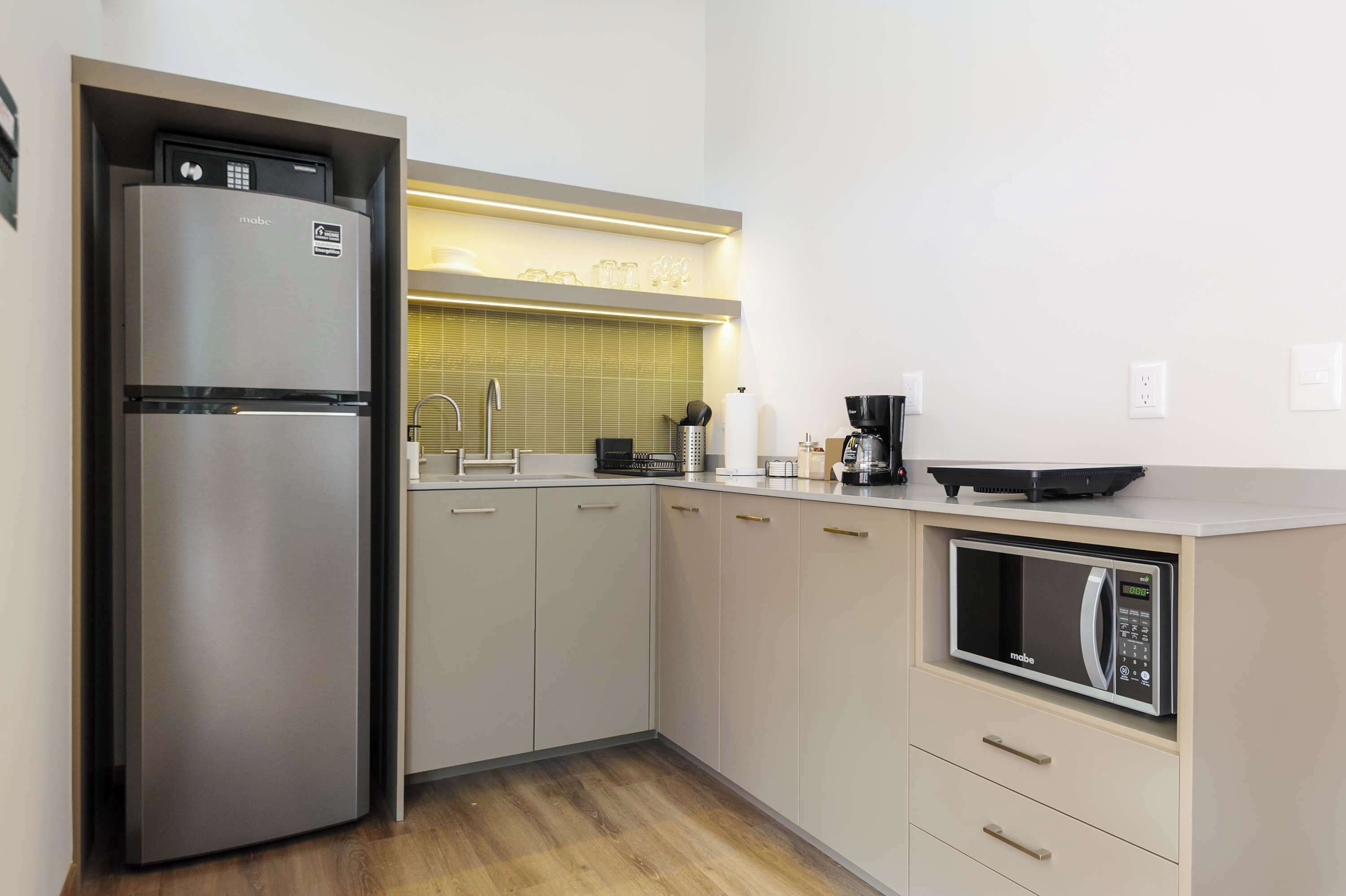 A modern kitchen with a built-in refrigerator, a microwave, and a coffee maker.