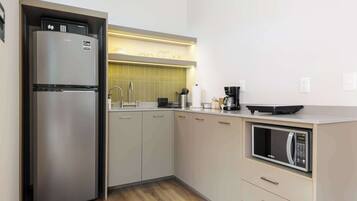 A modern kitchen with a built-in refrigerator, a microwave, and a coffee maker.