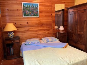 A wooden-paneled room with a bed, two bedside tables, a lamp, and a painting on the wall. - Bedroom & Bathroom in a large chalet. Motorcyclists are welcome! (Barcelonnette)