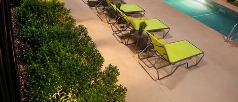 A poolside area with lounge chairs and a swimming pool.