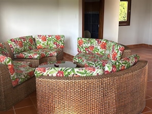 A wicker sectional sofa with floral upholstery in a room with tiled flooring. - Coffee farm 15 minutes from the coffee park (rural)