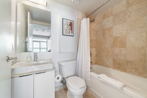 Ein modernes Badezimmer mit Toilette, Waschbecken und Badewanne.