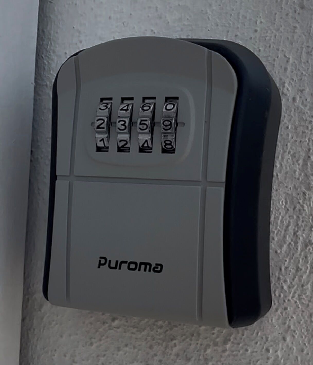 En vægmonteret dør lås med numerisk tastatur og mærket 'Puroma'.