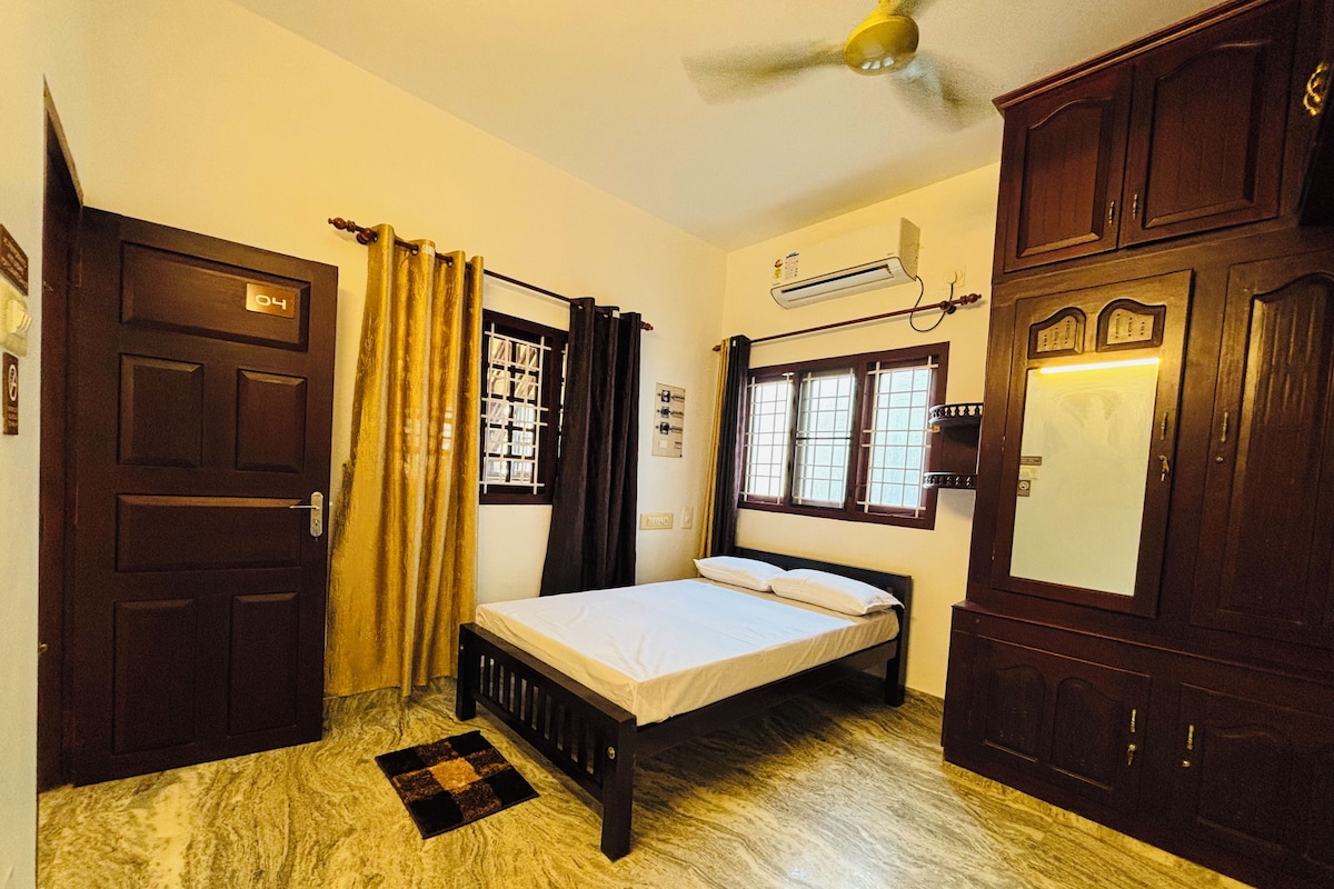A bedroom with a bed, a door, a window with curtains, a ceiling fan, and a wall-mounted air conditioner.