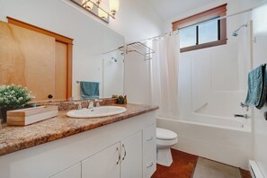 A bathroom with a sink, toilet, shower, and a window. - Cabin Retreat w/Sauna & Cold Plunge (Salt Spring Island)