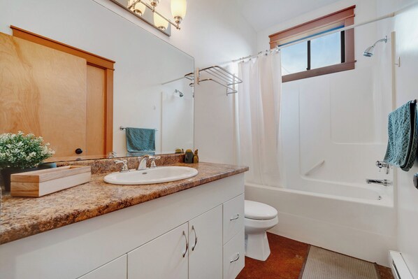 A bathroom with a sink, toilet, shower, and a window. - Cabin Retreat w/Sauna & Cold Plunge (Salt Spring Island)