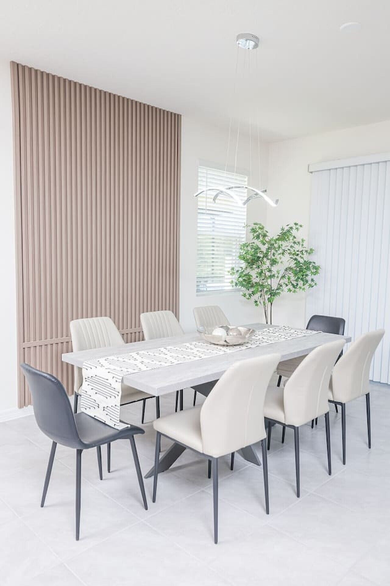 Ein stilvolles Esszimmer mit einem rechteckigen Tisch, sechs Stühlen und einer Zimmerpflanze.