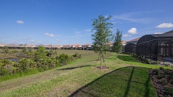 A residential area with houses, a grassy field, and a greenhouse structure.