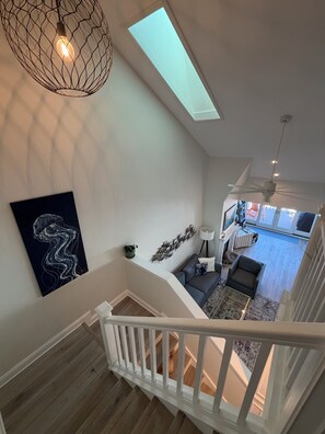 A modern interior with a staircase, a ceiling fan, a skylight, and a view of the living area below. - Spacious 3-bedroom condo in charming Tierra Verde on the Grand Canal (Tierra Verde)