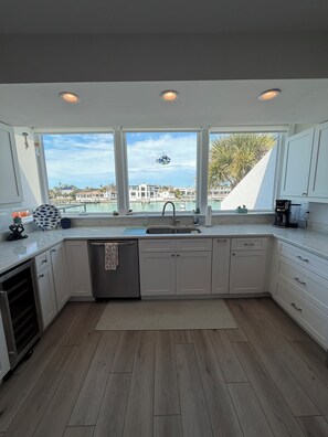 A modern kitchen with a large window, a sink, and a dishwasher. - Spacious 3-bedroom condo in charming Tierra Verde on the Grand Canal (Tierra Verde)