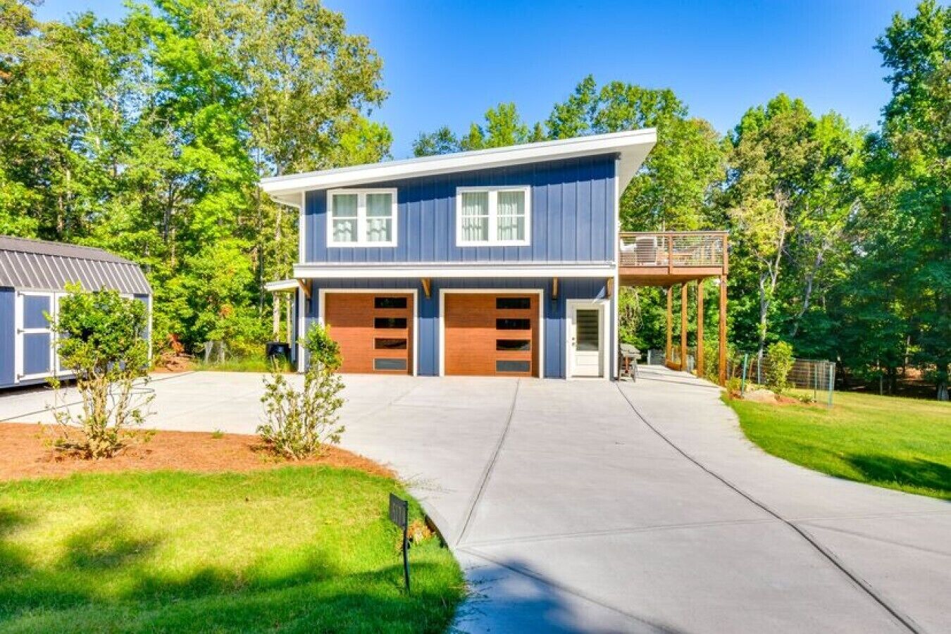 Ein zweistöckiges Haus mit Garage, überdachter Veranda und gepflegtem Rasen.