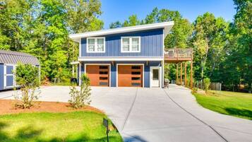 A two-story house with a garage, a covered porch, and a well-maintained lawn.