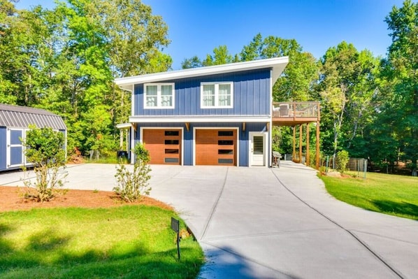 A two-story house with a garage, a covered porch, and a well-maintained lawn.