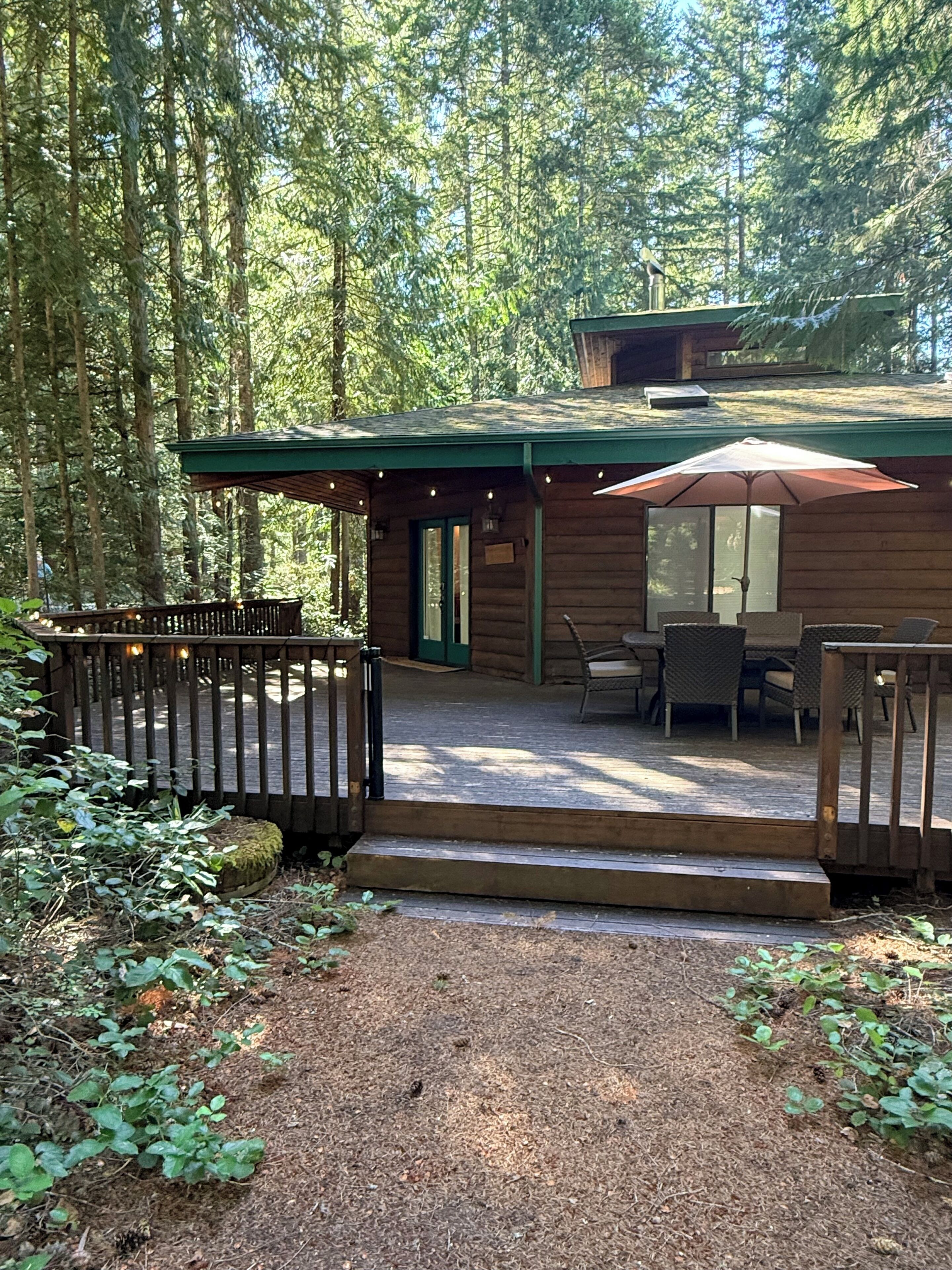 Eine Hütte mit einer Terrasse, Sitzgelegenheiten im Freien und einer überdachten Veranda.