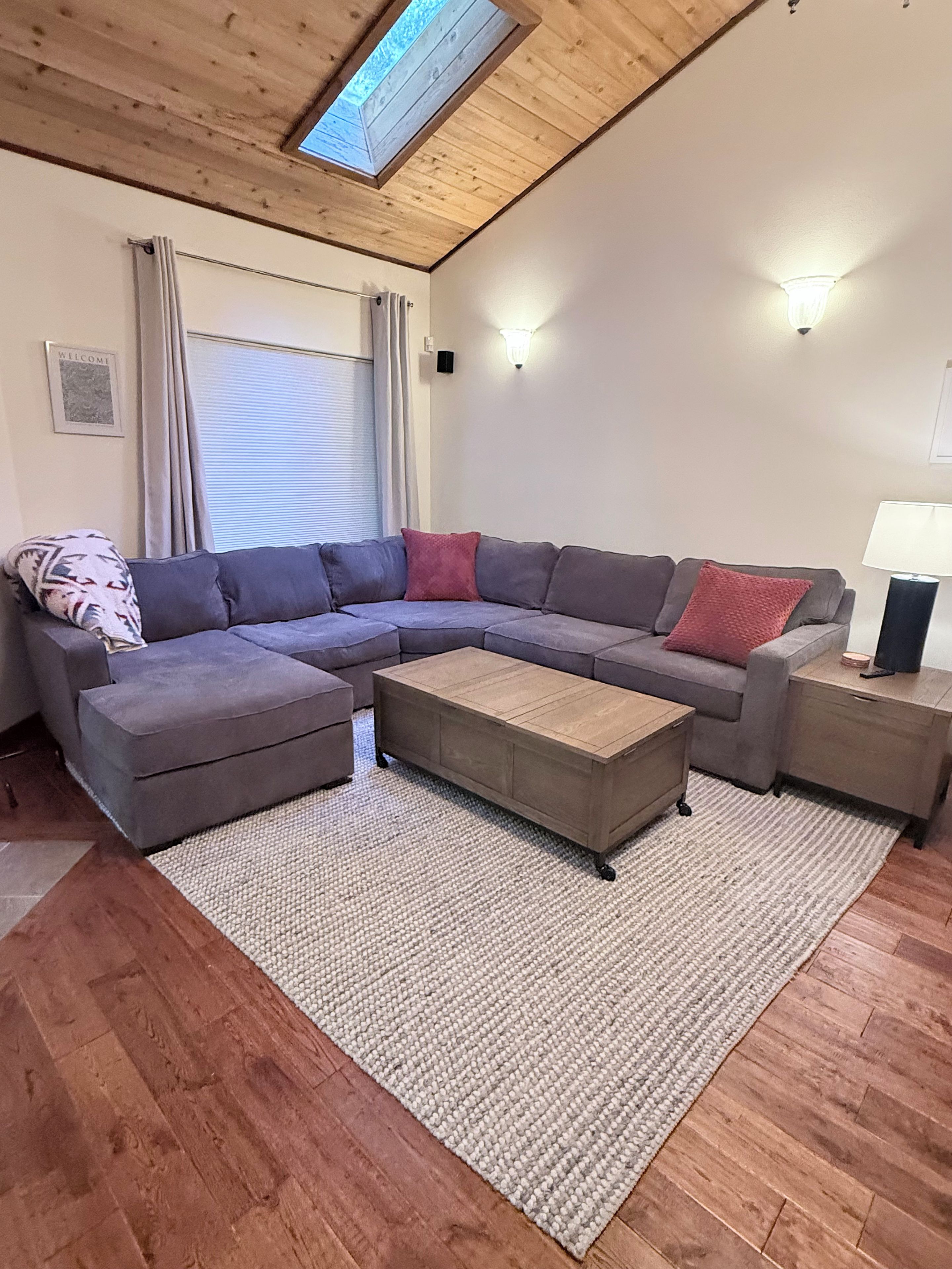 A modern living room with a sectional sofa, a coffee table, and a side table.