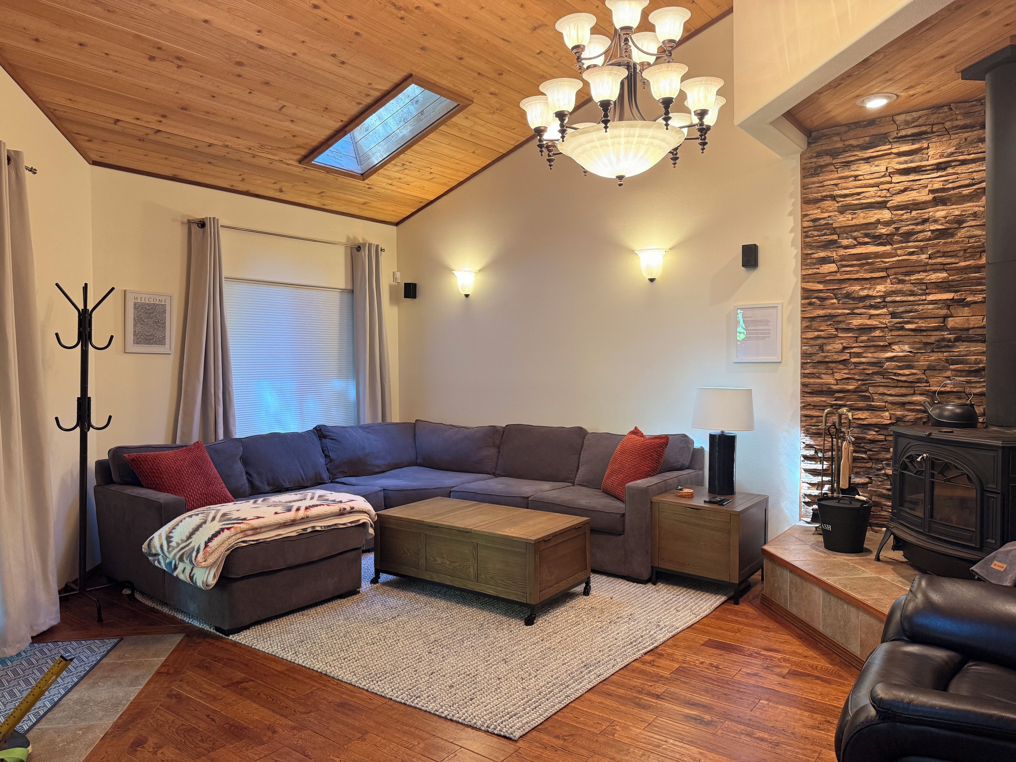 Ein modernes Wohnzimmer mit einer Eckcouch, einem Kamin und einer Wand mit Steinverkleidung.