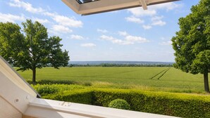 A balcony with a view of a green field and trees. - Meerbeck Vacation Rental (Meerbeck)