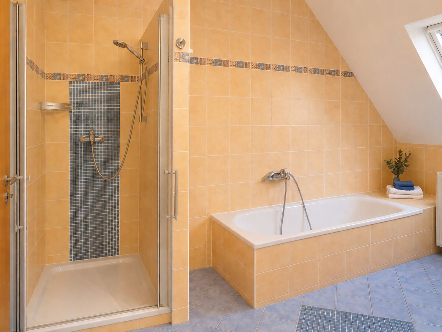 Een badkamer met een douche met glazen wand, een bad en een betegelde vloer.