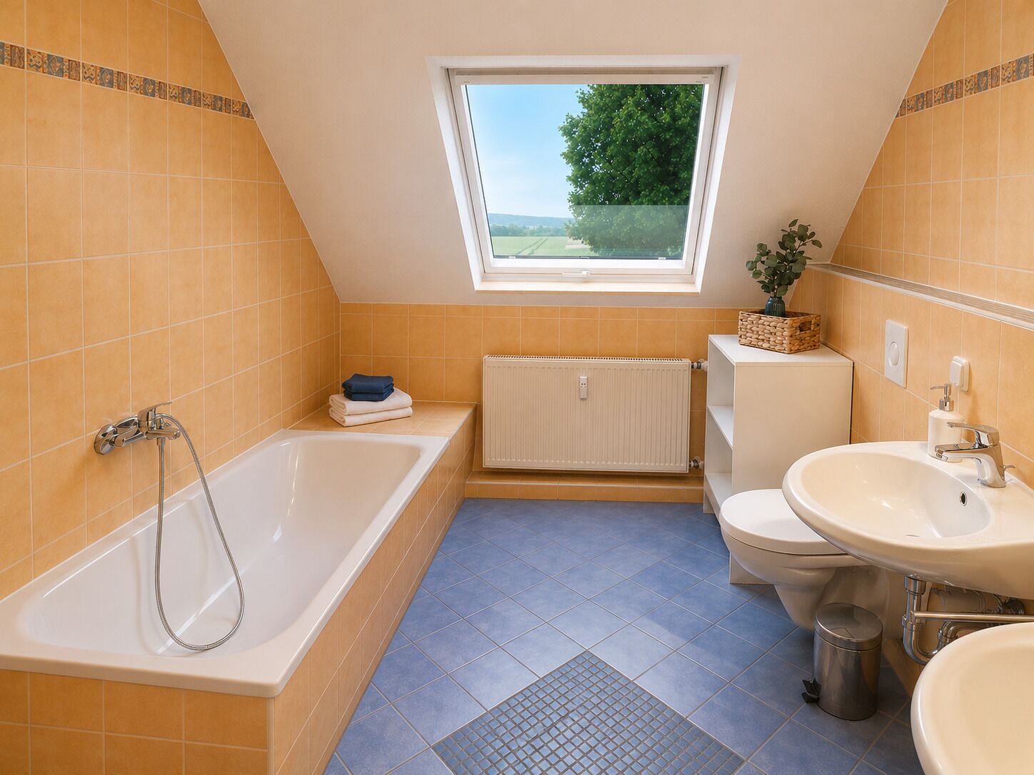 Ein Badezimmer mit Badewanne, Toilette und Waschbecken, ein Fenster mit Blick und eine Heizung.