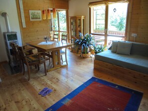 Un intérieur en bois comprenant une table à manger, des chaises, un canapé et une grande fenêtre.